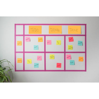 Um quadro Kanban montado na parede exibe Post-it® Super Sticky Notes coloridos da 3M Deutschland GmbH (76x127mm, 90 folhas, 100% PEFC), rotulados com tarefas e nomes nas colunas "A fazer", "Em andamento" e "Concluído". No canto inferior esquerdo, aparece uma planta verde.