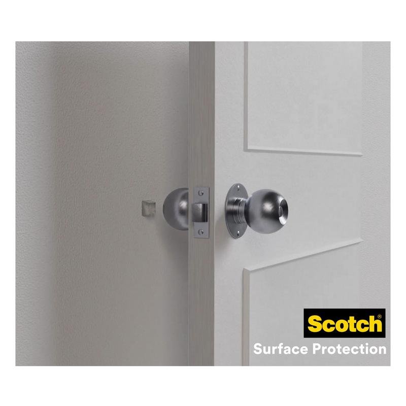 Uma porta branca com uma maçaneta redonda prateada está aberta e amassa a parede clara. Os amortecedores elásticos Scotch® para paredes SP91A64 da 3M Deutschland GmbH (autoadesivo, transparente, Ø 22 mm) oferecem proteção eficaz para paredes; logotipo visível no canto inferior direito.