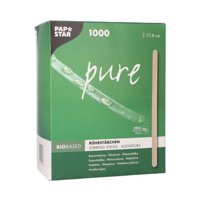 Numa caixa verde com a inscrição "PAPSTAR 'pure'" da PAPSTAR GmbH, encontram-se 1000 colheres de mexer sem lascas de madeira de bétula com um comprimento de 17,8 cm cada, com a impressão "biobased" em várias línguas na frente e uma colher de madeira vertical ilustrada.