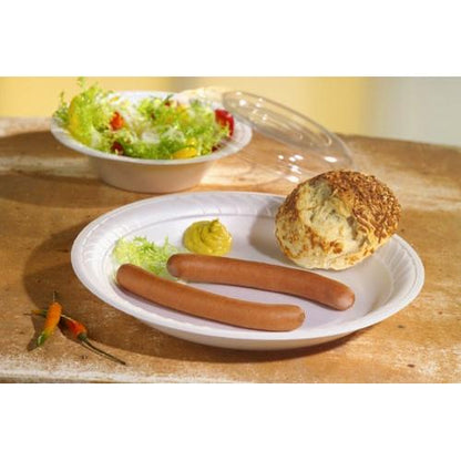 Um prato de papelão com duas salsichas, mostarda, salada e um pãozinho. Ao fundo, há uma tigela de salada com a tampa Starpak 50 Dom, R-PET redonda Ø 15,5 cm · 2,5 cm transparente | Película retrátil (50 unidades) e três pequenas pimentas nozes na mesa.
