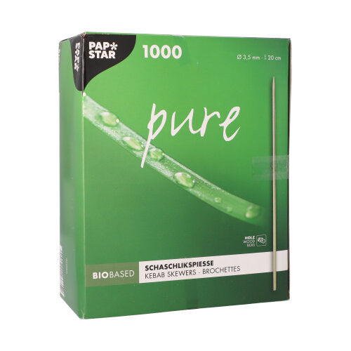 Uma caixa verde com a inscrição "PAPSTAR espetos de madeira 'pure', Ø 3,5 mm, 20 cm de comprimento | bandeja de papelão (1000 peças)" da PAPSTAR GmbH contém 1000 espetos de madeira e mostra uma imagem de espeto com gotas de água sobre fundo verde brilhante.