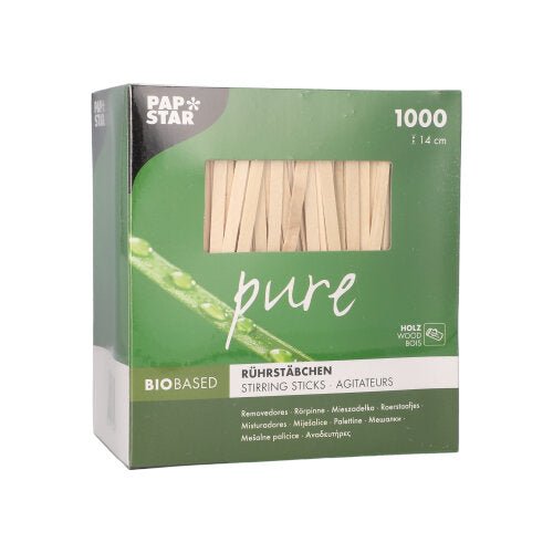 Uma caixa verde-branca PAPSTAR "pure" contém 1000 colheres de mexer sem lascas, de 14 cm de comprimento, feitas de madeira de bétula biobaseada da PAPSTAR GmbH. O nome da marca aparece no canto superior esquerdo da embalagem.