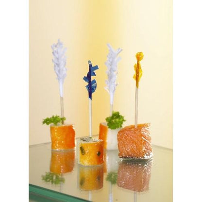 São servidas quatro entradas em porções individuais, cada uma espetada com um PAPSTAR 1000 palitos decorativos 6,8 cm "Frills" da PAPSTAR GmbH, com peixe e legumes, decorados com salsa para uma apresentação elegante.