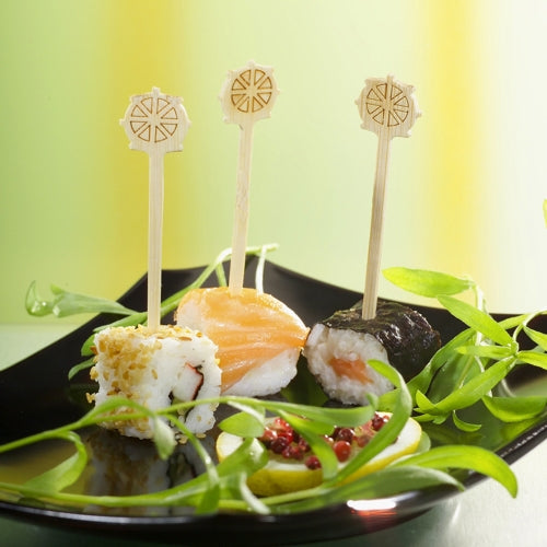 Três pedaços de sushi em um prato preto, cada um com cobertura única e seguro com o PAPSTAR palito de finger food "Volante" 9 cm da PAPSTAR GmbH, são perfeitos para festas. Guarnição verde e molho vermelho adornam o prato e oferecem um catering estiloso com a bandeja de papelão (200 unidades).