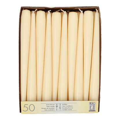 Uma caixa com a inscrição "Starpak 50 velas Ø 2,2 cm - 25 cm" contém 50 velas brancas dispostas verticalmente em duas filas. Na frente da caixa há um texto multilíngue e o número 50.