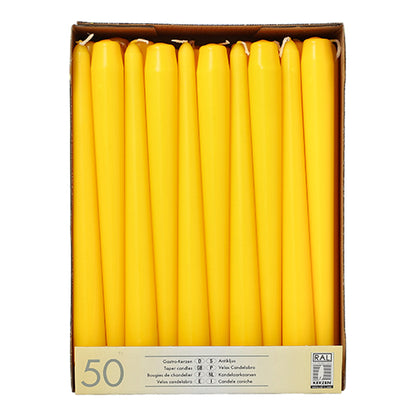 Uma caixa de papelão da Starpak contém 50 velas brancas (Ø 2,2 cm - 25 cm), dispostas verticalmente em filas. A etiqueta na frente contém informações do produto em várias línguas, incluindo "velas de parafina.