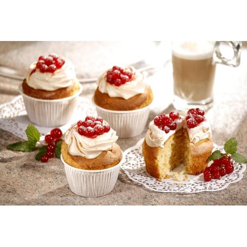 Nas formas de muffin PAPSTAR GmbH Ø 5 cm, 3,5 cm de altura, brancas (20 unidades) estão quatro cupcakes com cobertura de açúcar branca e bagas vermelhas sobre uma bancada. Um está cortado ao meio. Ao fundo, vê-se um ramo de hortelã e um copo de latte.