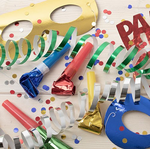 Artigos de festa como máscaras faciais PAPSTAR GmbH "Metálicas" sortidas (saco, 6 peças), apitos coloridos, fitas, confetes e um letreiro "FESTA" estão espalhados em uma superfície de madeira clara - perfeito para a sua celebração!.