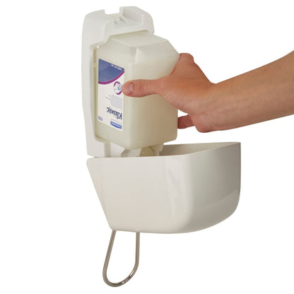 Uma mão insere um cartucho de 1 Ltr do dispensador Aquarius™ para loções de lavagem da Kimberly-Clark GmbH em um dispensador branco montado na parede com frente curva e suporte de metal abaixo.