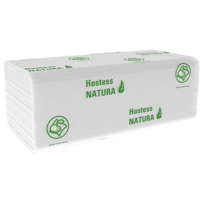 Um monte de toalhas Hostess™ NATURA™ brancas dobradas (Kimberly-Clark GmbH), Grandes, 20 x 84 folhas, com marca verde e símbolo de polegar para cima. Feito na Alemanha - toalhas de papel ideais para áreas públicas. 20 pacotes por caixa.