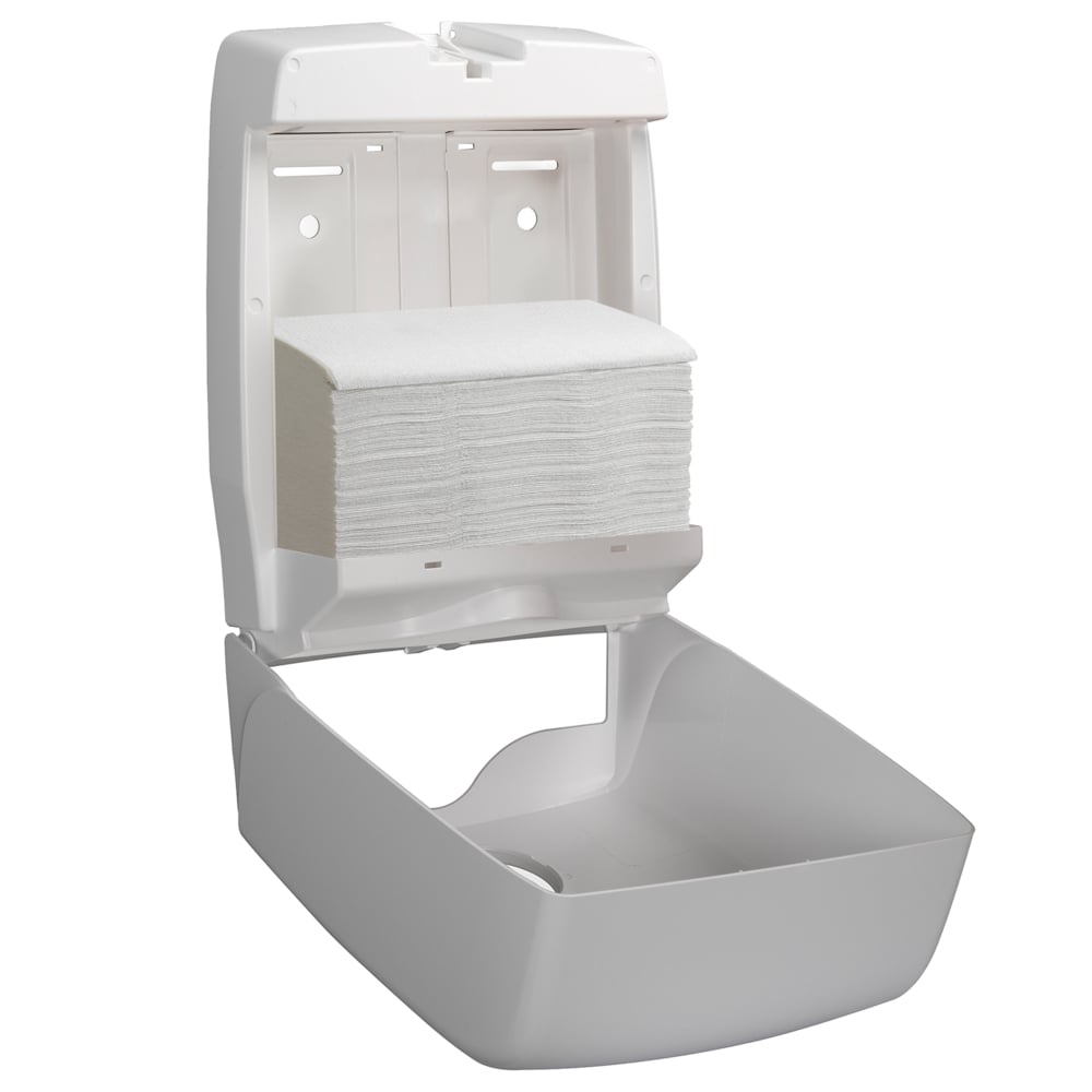 Um dispensador de parede branco está aberto e mostra uma pilha de toalhas Hostess™ NATURA™ - dobragem em ziguezague, Pequena (23 x 25 cm) da Kimberly-Clark GmbH. A tampa está levantada, o compartimento inferior permanece vazio.