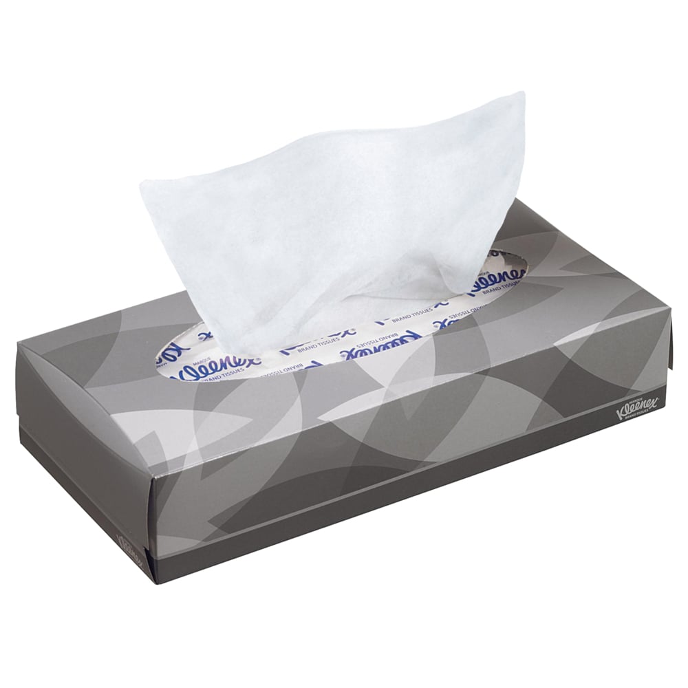 Uma caixa retangular cinza com lenços de cosméticos Kleenex® - Standard / Branco da Kimberly-Clark GmbH, de onde é puxado um único lenço branco. Padrão sutil de folhas e texto da marca. Ideal para remoção de maquiagem ou limpeza facial.