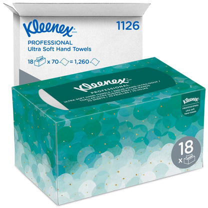 Uma caixa de toalhas de mão Kleenex® Ultra™ Interfold (branco, médio, 70 unidades) da Kimberly-Clark GmbH é mostrada à frente de uma caixa de envio branca com as inscrições "1126" e "18 x 70 = 1.260", contendo 18 pacotes de higiene.
