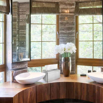 Uma casa de banho moderna com uma bancada de madeira, duas pias brancas, persianas marrons, um vaso com flores brancas e um elegante dispensador de toalhas Kleenex® em aço inoxidável da Kimberly-Clark GmbH com função de caixa de puxar ao lado da caixa de lenços. Árvores são visíveis lá fora.