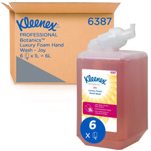 Eine rote 1-Liter-Kassette Kleenex® Botanics™ Luxury Foam Hand Wash der Kimberly-Clark GmbH steht vor einer "6387"-Schachtel, die sechs 1-Liter-Kassetten enthält, mit sichtbarem Branding und pflanzlichen Inhaltsstoffen.