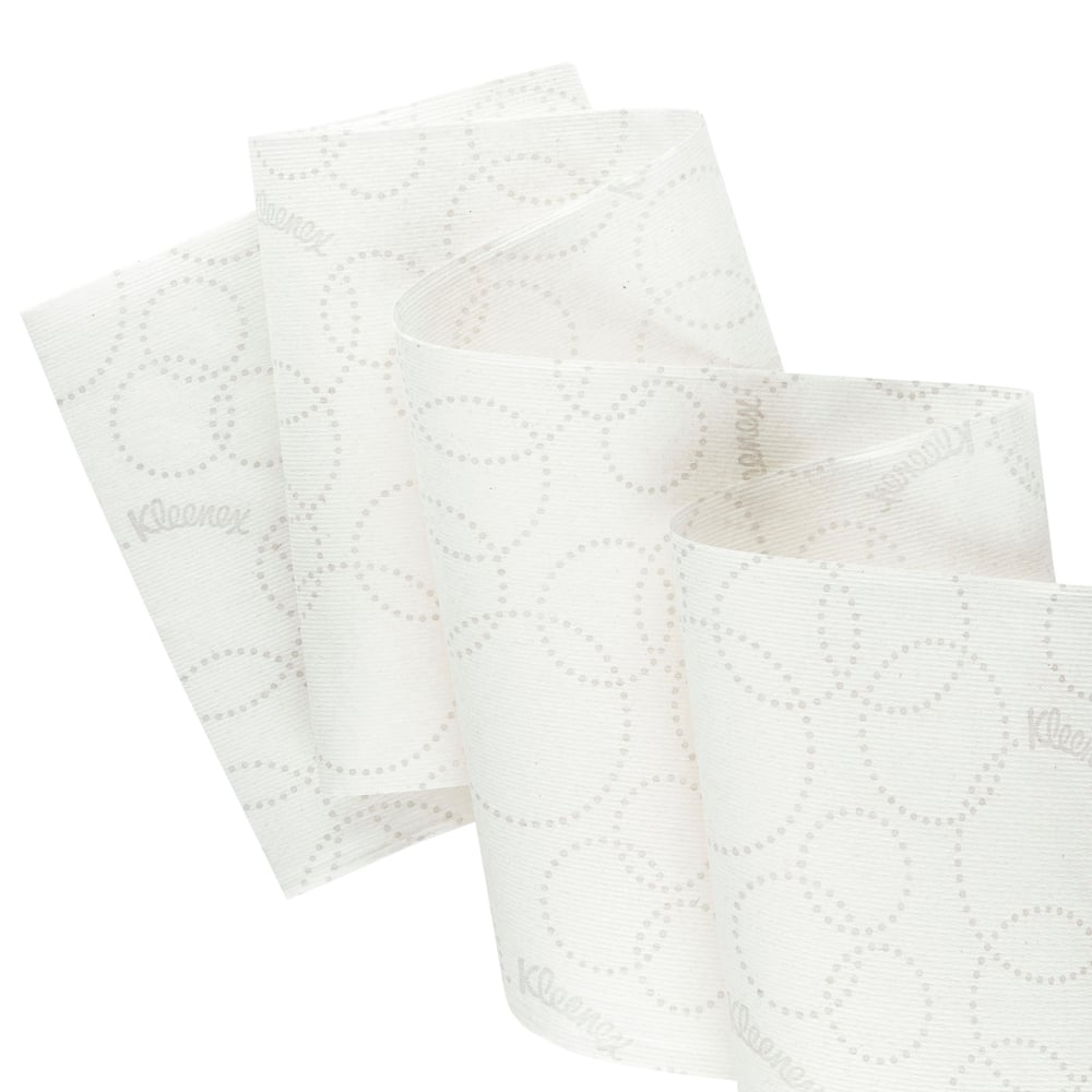 Close-up de um rolo branco de toalhas de mão Kleenex® Ultra™ Slimroll™ da Kimberly-Clark GmbH com um padrão pontilhado discreto e parcialmente desenrolado, para mostrar sua adequação para sistemas de dispensadores estreitos; 6 rolos por caixa.