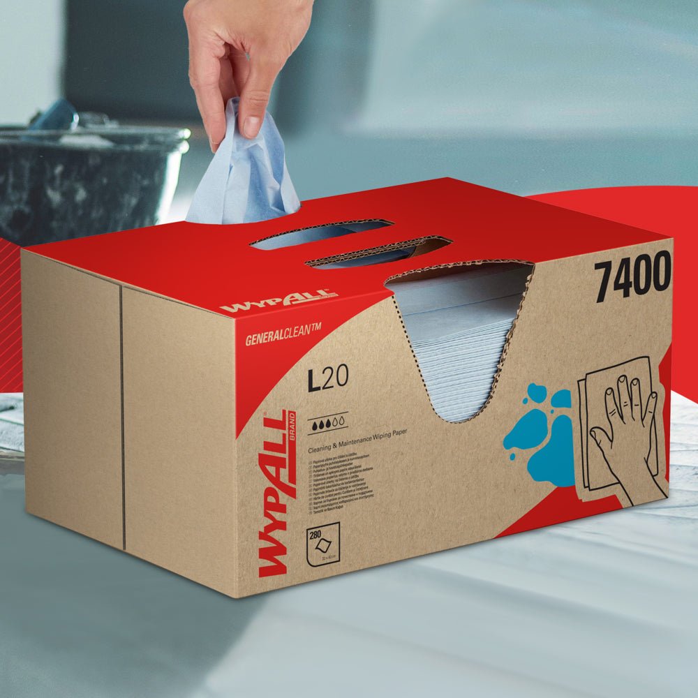 Uma mão puxa um toalhete WypAll® L20 General Clean de uma caixa azul BRAG™ da Kimberly-Clark GmbH, que contém 280 folhas, e coloca-o sobre uma superfície lisa.