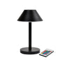 A lâmpada LED Zelda Midi da Duni GmbH em design moderno de grafite com base redonda e abajur cônico está ao lado de um controle remoto com botões coloridos - a solução de iluminação ideal e eficiente em termos de energia.