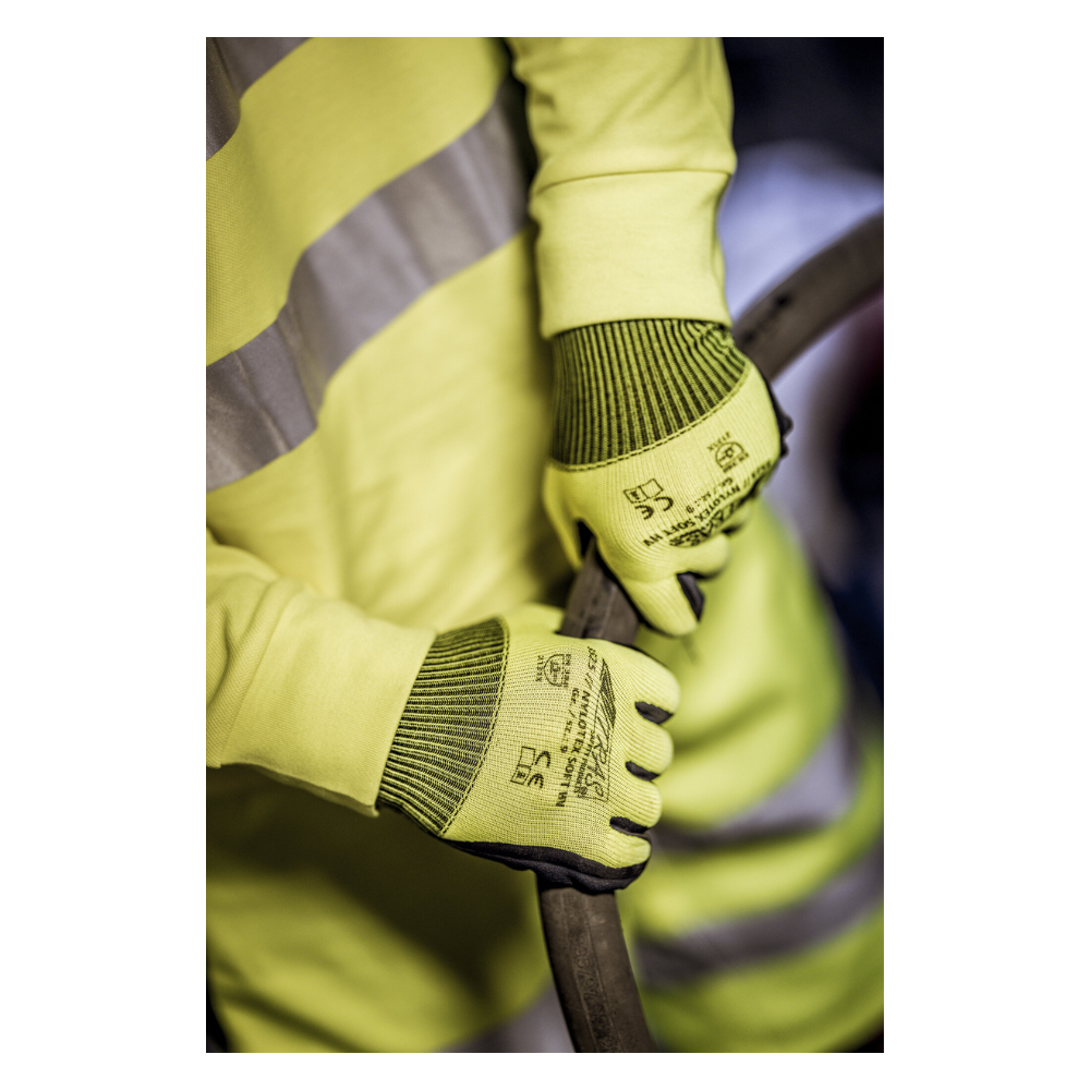 Uma pessoa vestindo um colete de segurança amarelo e luvas de nylon NITRAS NYLOTEX SOFT HV da AS Arbeitsschutz GmbH, amarelo neon, parcialmente revestidas - com texto preto e símbolos de segurança - segura um cabo ou mangueira grosso e escuro.