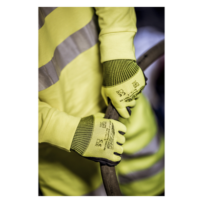 Uma pessoa vestindo um colete de segurança amarelo e luvas de nylon NITRAS NYLOTEX SOFT HV da AS Arbeitsschutz GmbH, amarelo neon, parcialmente revestidas - com texto preto e símbolos de segurança - segura um cabo ou mangueira grosso e escuro.