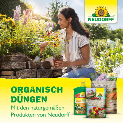 Uma mulher planta flores com uma espátula entre azevinho e buxo. Em primeiro plano está o Azet Buxus- & IlexDünger da Neudorff Shop. O texto em alemão destaca as vantagens orgânicas da adubação com produtos Neudorff.