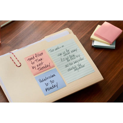 Em uma pasta sobre uma mesa de madeira, há três notas recicladas Post-it® (3M Deutschland GmbH, 38 mm x 51 mm, 100 folhas/bloco, 100% PEFC) com anotações. Perto estão papéis coloridos empilhados.