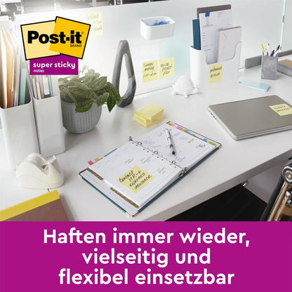Uma mesa moderna exibe itens com Post-it® Super Sticky 100% Notas de Reciclagem (47,6x47,6 mm, 70 folhas/bloco, 100% PEFC) da 3M Deutschland GmbH. Texto em alemão: "Adesão repetida, uso versátil e flexível.