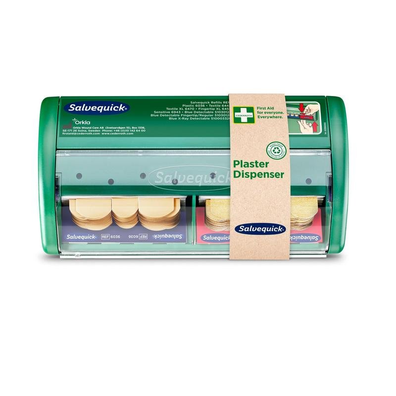 O dispensador de pensos Salvequick da Orkla Wound Care AB é um dispensador verde com frente transparente, com dois compartimentos para pensos e uma etiqueta castanha no lado direito com a inscrição "Dispensador de Pensos". Embalagem (1 unidade).