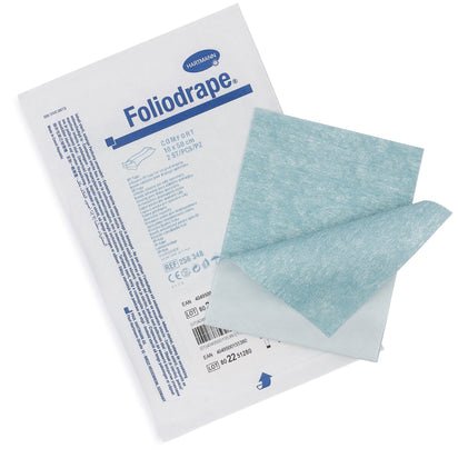 Um pacote de fitas adesivas cirúrgicas Foliodrape 10x50 da Paul Hartmann AG (pacote, 115 peças) está ao lado de dois panos azul e branco não dobrados para a fixação de coberturas cirúrgicas em ambientes estéreis de operação.