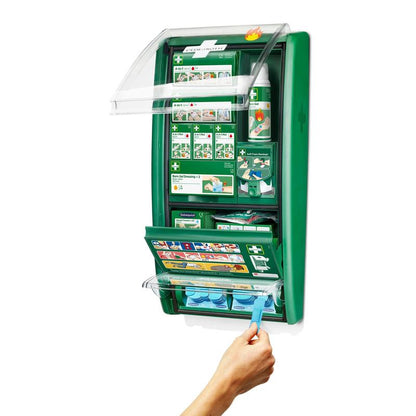 Uma estação de primeiros socorros e queimaduras Cederroth da Orkla Wound Care AB montada na parede está aberta e mostra materiais de consumo como curativos, instruções, frascos de lavagem ocular e uma mão que pega uma cápsula de lavagem ocular azul do compartimento inferior. (1 embalagem/caixa).