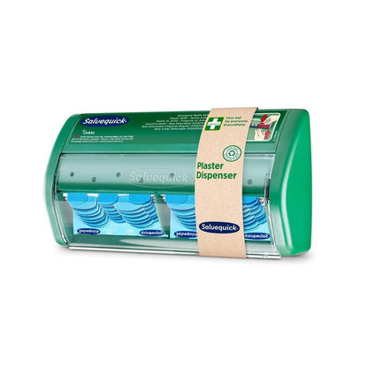 Um dispensador de pensos transparente e verde Salvequick da Orkla Wound Care AB, que contém pensos azuis detectáveis. Na frente encontra-se uma informação do produto e uma faixa bege com a inscrição "Dispensador de Pensos". Embalagem (1 unidade).