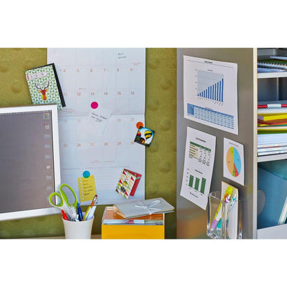 Um espaço de trabalho com calendário, monitor e material de escritório, onde tabelas e gráficos são fixados à parede com Scotch-FIX™ Almofadas Adesivas Removíveis 301008C36-P (11 mm x 15 mm, 36 unidades/pacote) da 3M Deutschland GmbH, próximo a prateleiras com pastas e cadernos.