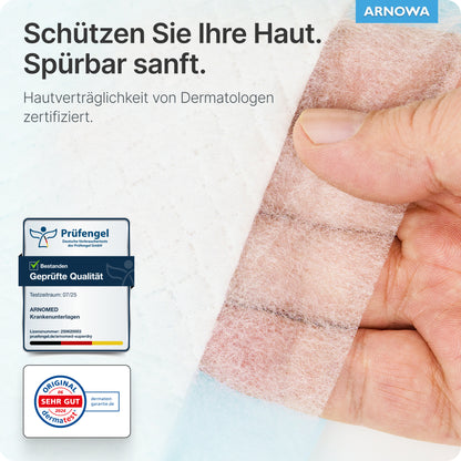 Uma mão retira uma bandagem transparente de um pad ARNOMED SUPERDRY PLUS da ARNOWA GmbH. O texto em alemão destaca a proteção da pele, a certificação dermatológica e os selos de qualidade, com o logotipo da ARNOWA visível no canto superior direito.