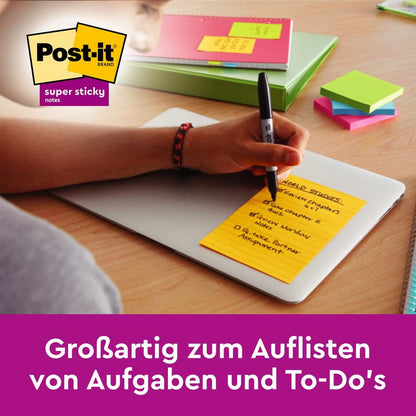 Alguém escreve em um Post-it® Super Sticky Notes amarelo em grande formato, Boost Collection (101 mm x 152 mm, pautado, 45 folhas/bloco, 3 blocos/pacote) da 3M Deutschland GmbH; texto em alemão: "Ótimo para listar tarefas e afazeres."