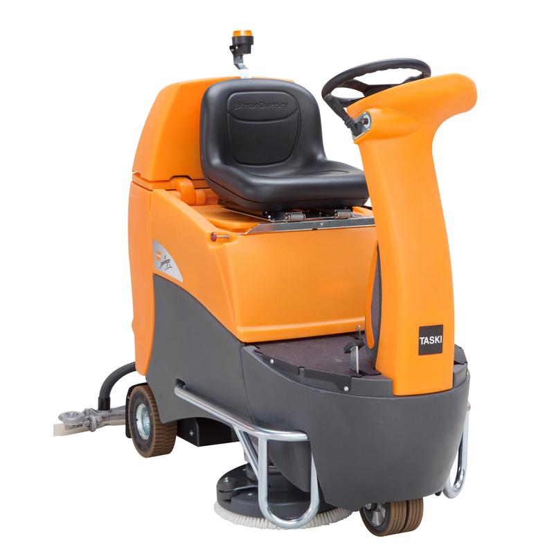 A TASKI swingo 2500 da Diversey Deutschland é uma máquina de limpeza compacta e económica com operador a bordo, com uma carcaça cinza-laranja, volante, assento preto, escovas visíveis, tecnologia de lítio e dosagem dependente da velocidade.