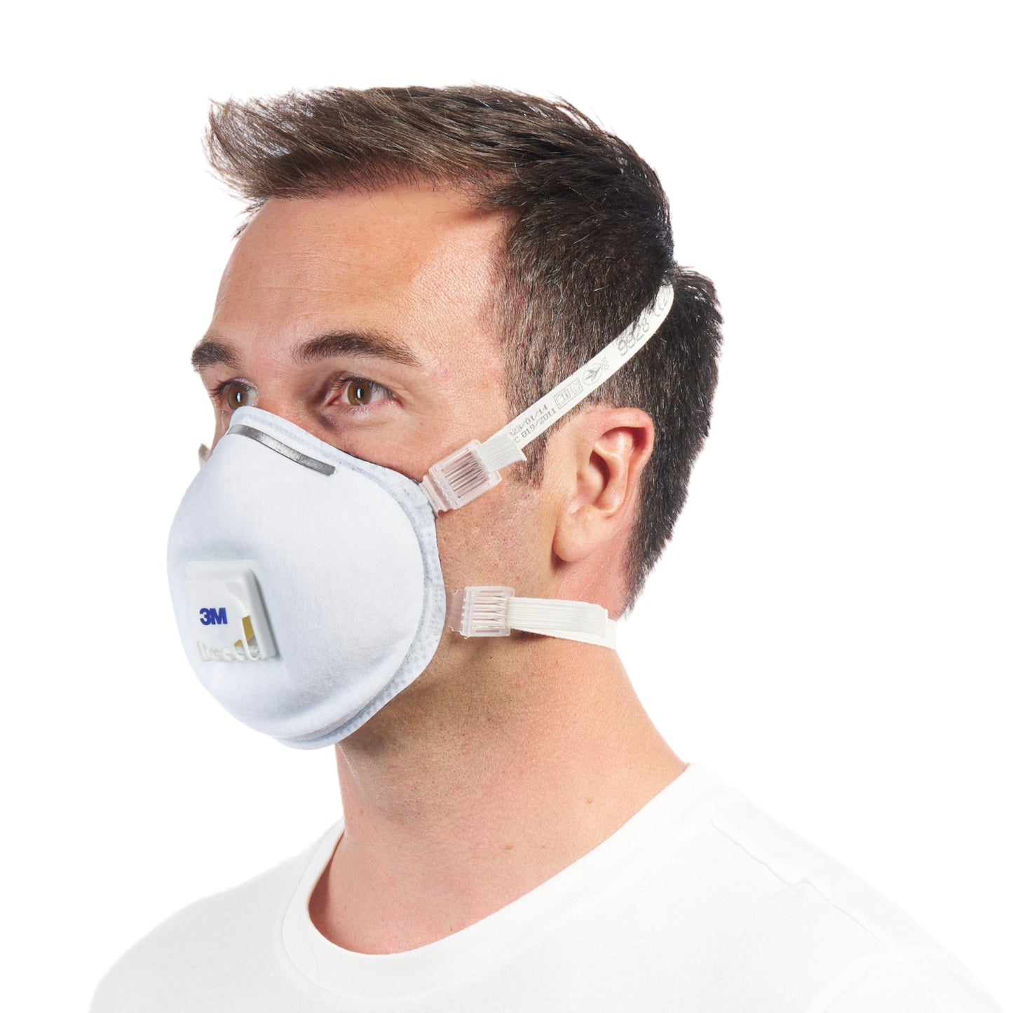 Ein Mann mit kurzen braunen Haaren im Profil trägt eine 3M™ Cool Flow™ Partikelmaske 9928 für Schweißarbeiten, mit Ventil (1 Stück) von 3M Deutschland GmbH, befestigt mit zwei elastischen Bändern, vor einem schlichten weißen Hintergrund.