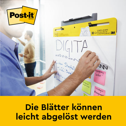 Eine Person schreibt auf ein 3M Deutschland GmbH Post-it® Super Sticky selbsthaftendes Meeting Chart/Flipchart für Wand-Montage 566 (58,4 x 50,8 cm, weiß), das mit Command™-Streifen an einem Whiteboard befestigt ist; bunte Haftnotizen sind darauf angebracht.