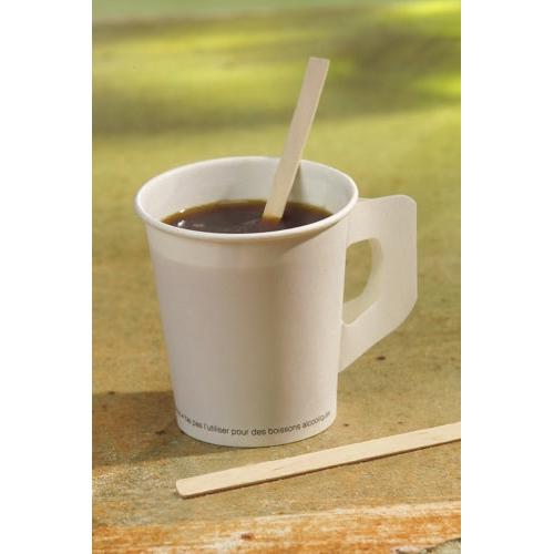 Um copo de papel branco com alça plana contém café escuro e uma PAPSTAR vara de mexer de madeira "pure" (14 cm, ecológica, estável); outra está ao lado. Ambas as varas de mexer são da PAPSTAR GmbH e são fornecidas numa caixa de 1000 unidades.