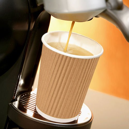 Uma máquina de café despeja café em um copo Starpak 25, um copo "To Go" Ripple Wall de papelão na bandeja de metal, contra um fundo de tom quente.