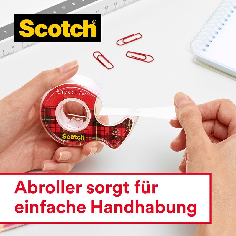 Uma mão puxa fita adesiva Scotch® Crystal (19 mm x 25 m, 1 rolo) de um dispensador vermelho da 3M Deutschland GmbH. Clips vermelhos, um caderno e uma régua estão em uma superfície branca. Texto em alemão: "O dispensador proporciona fácil manuseio."
