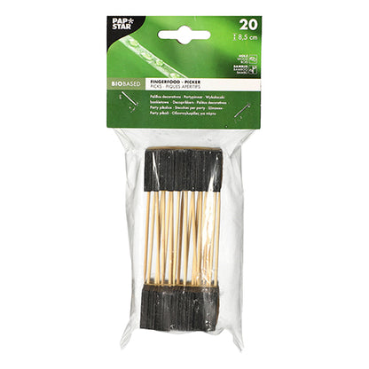 Uma embalagem de plástico transparente contém 20 palitos para finger food PAPSTAR, 8,5 cm, pretos - ideal para buffets e festas. A etiqueta superior mostra detalhes do produto em fundo verde com texto branco. Marca: PAPSTAR GmbH.