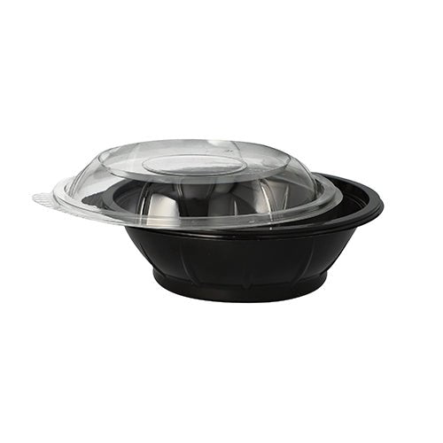 Sobre um fundo branco simples, está ilustrada uma tigela de salada preta Starpak de PET (600 ml) com tampa transparente e abaulada 'Snap It' de R-PET, ligeiramente inclinada.