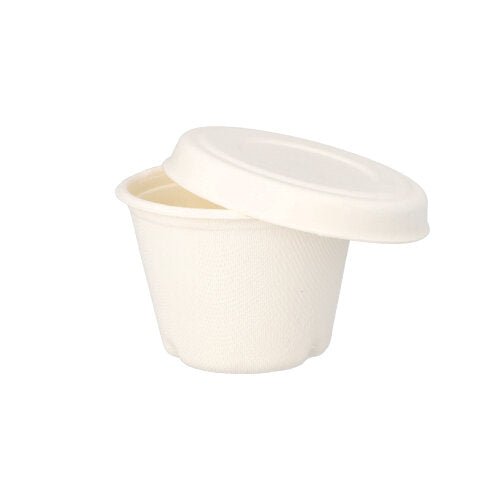 Uma pequena tampa de copo de molho "pure" de cana-de-açúcar branca da PAPSTAR GmbH com uma superfície lisa e mate e design simples, parcialmente aberta sobre um copo correspondente em um fundo branco.