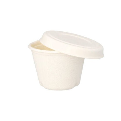 Uma pequena tampa de copo de molho "pure" de cana-de-açúcar branca da PAPSTAR GmbH com uma superfície lisa e mate e design simples, parcialmente aberta sobre um copo correspondente em um fundo branco.