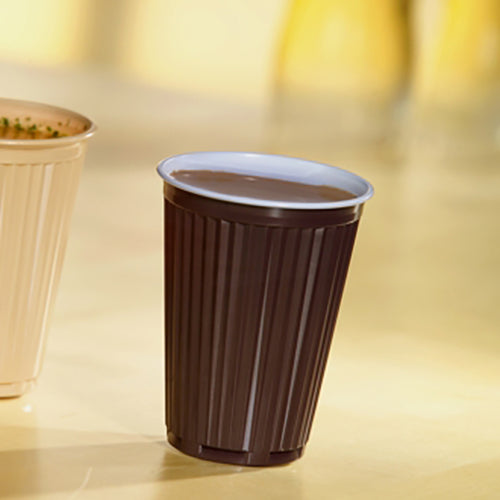 Um copo automático térmico Starpak 100 (PS, 0,18l, Ø7,03cm, 9cm, castanho/branco) cheio de bebida está sobre uma superfície clara ao lado de outro copo; ideal para bebidas em movimento. Embalagem com 100 unidades.