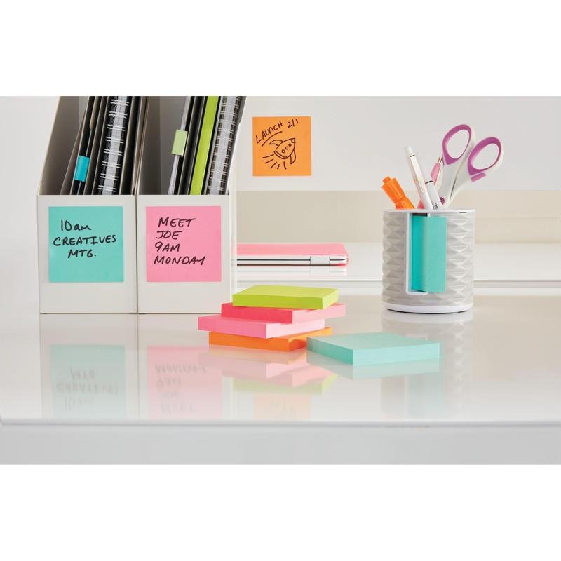Uma mesa branca organizada com cubos de notas adesivas Post-it® da 3M Deutschland GmbH, cores ultra (76 mm x 76 mm, 450 folhas), cadernos, pastas em suportes e notas adesivas em tons pastel. Na mesa e na parede, lembretes e horários de reuniões são exibidos nos papéis.