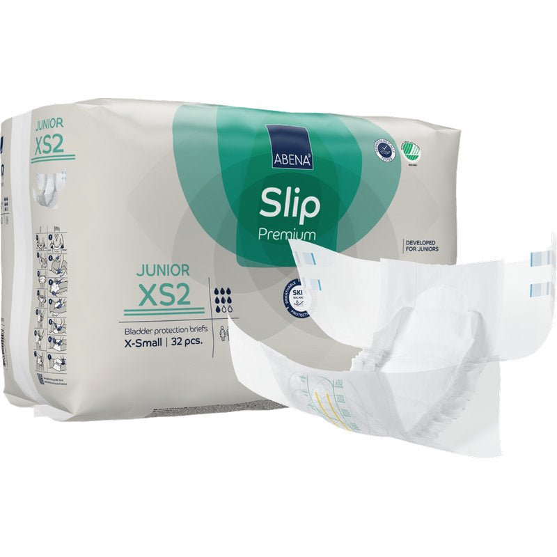 Um pacote ABENA Slip Junior Premium Gr XS2 da Abena Re-Seller GmbH (32 unidades) é exibido com um produto de incontinência para crianças ao lado da embalagem verde e branca.