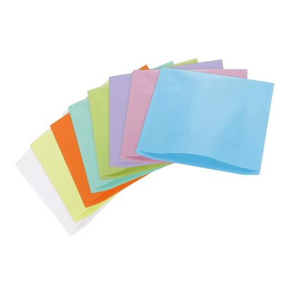 Um arranjo em forma de leque de guardanapos de papel coloridos nos tons de azul, rosa, verde, laranja, amarelo e branco, espalhados sobre um fundo branco, lembra os tons vibrantes geralmente encontrados nas capas de apoio de cabeça de seda do AMPri Dental da AMPri Handelsgesellschaft mbH.