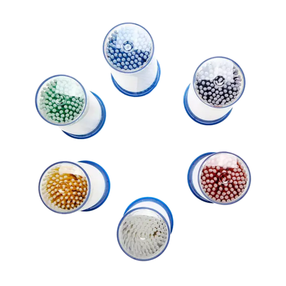 Os microaplicadores descartáveis AMPri MED-COMFORT, disponíveis em várias cores, estão dispostos em círculo e equipados com cerdas em azul, branco, preto, verde, amarelo e vermelho. Cada aplicador tem uma base azul e é visto de cima. Esta disposição é ideal para necessidades dentárias que exigem trabalho preciso com diferentes ferramentas codificadas por cores. Apresentado pela AMPri Handelsgesellschaft mbH.