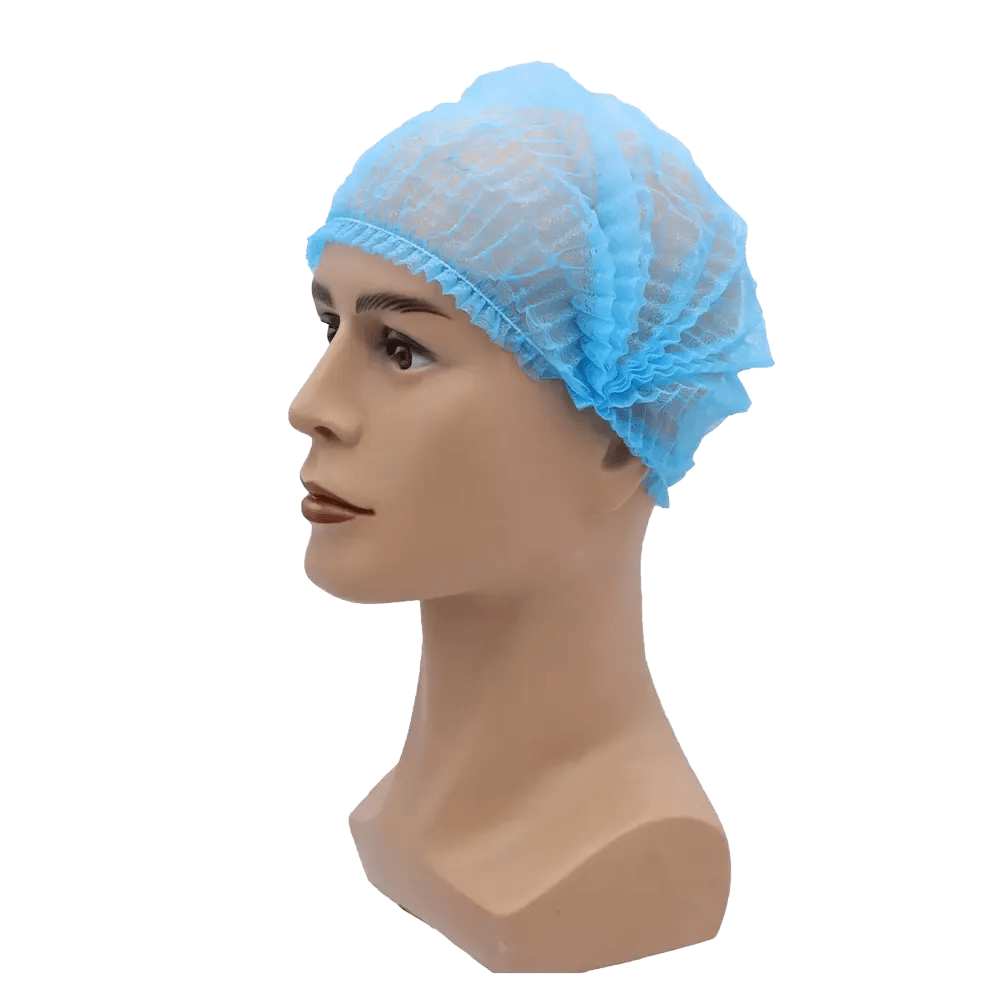 Uma cabeça de boneca usa uma touca azul AMPri MED-COMFORT Klipphaube 52 cm, da AMPri Handelsgesellschaft mbH. A rede para cabelo de polipropileno leve com bordas elásticas ajusta-se firmemente à cabeça da boneca e oferece proteção higiênica. A imagem é vista sobre um fundo branco simples.